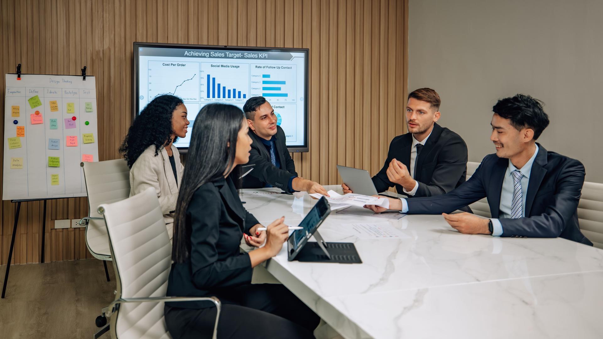Diverse team innovates for sales KPIs via collaborative brainstorming to develop business models.