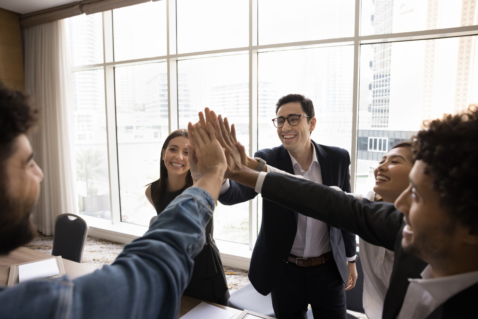 Multiethnic staff stack their palms together as gesture of unity